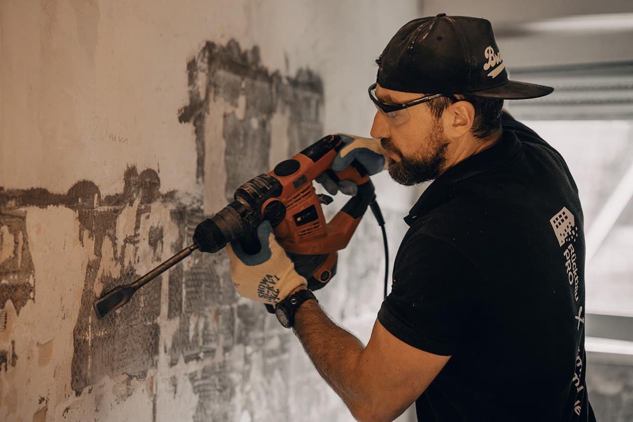 Mitarbeiter bei Wandarbeiten mit Bohrhammer