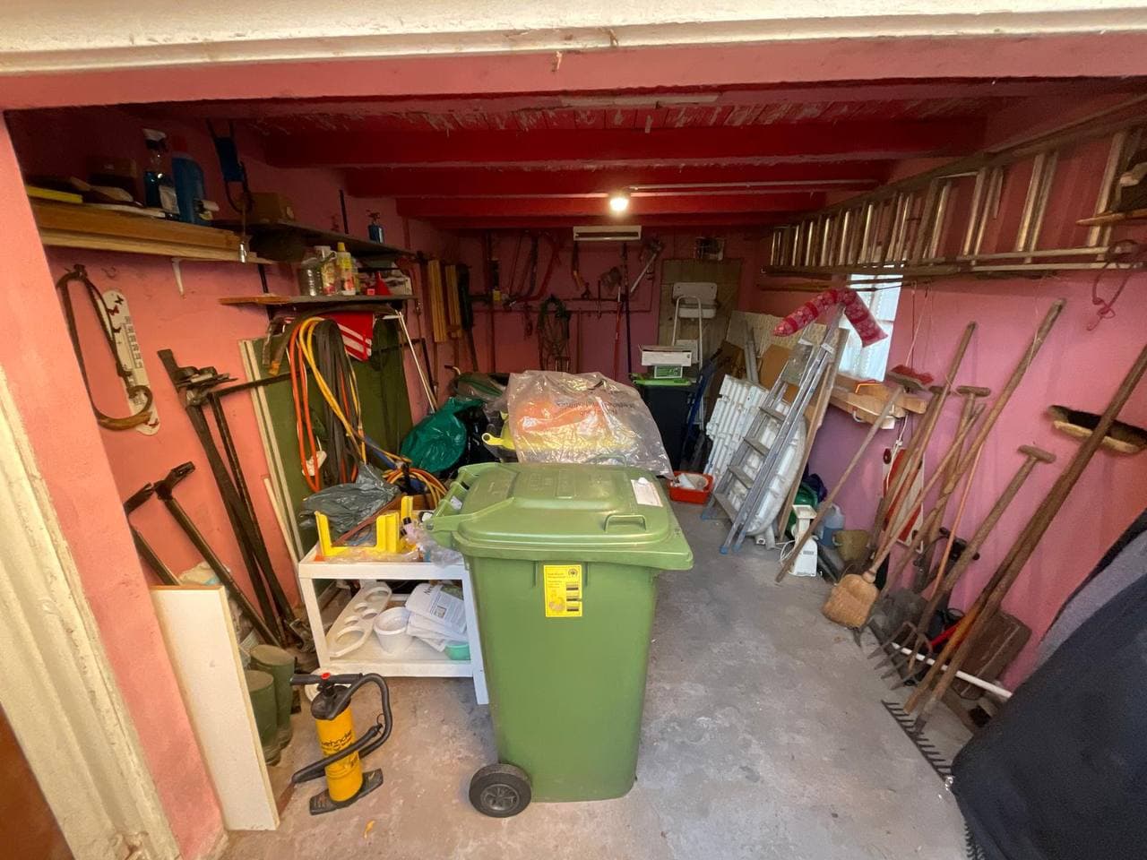 Volle Garage mit Werkzeug und Gartengeräten vor der Entrümpelung